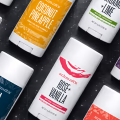 Schmidt’s deodorant sticks in assorted scents, laid out diagonally on a dark starfield